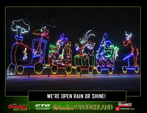 Colorful holiday light display featuring a train with festive characters, promoting a winter event.