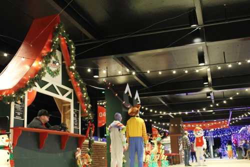 A festive indoor scene with holiday decorations, lights, and mannequins dressed in colorful costumes.