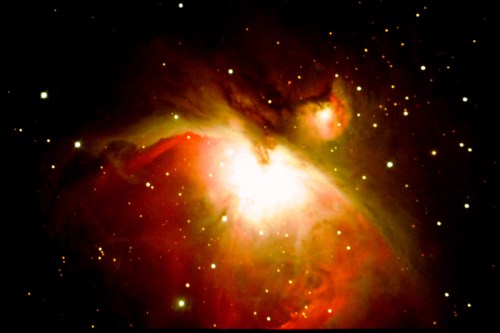 A vibrant cosmic scene featuring the Orion Nebula, with bright stars and swirling gas clouds in deep red and orange hues.