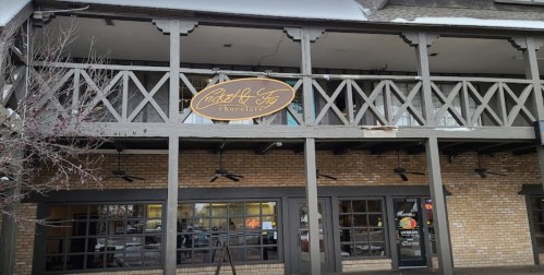 Exterior of a building featuring a sign for "Mabel & Fig Chocolates" with a rustic wooden balcony.