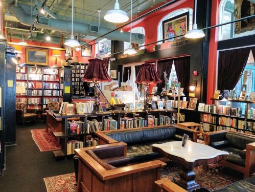 Cozy bookstore interior with bookshelves, comfortable seating, and warm lighting, creating an inviting reading atmosphere.