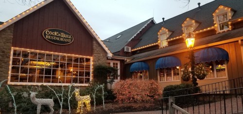 A cozy restaurant exterior decorated with holiday lights and a festive atmosphere.
