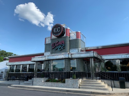 A retro-style diner with a shiny exterior, red accents, and a sign reading "EC Diner" against a blue sky.