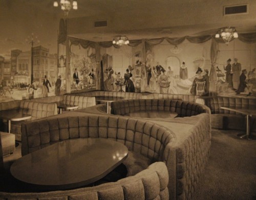 A vintage lounge with curved, tufted seating and a mural depicting elegant scenes from the past.