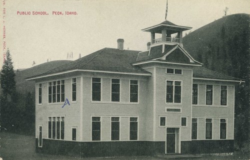 Historic image of the public school in Peck, Idaho, featuring a large, two-story building with a bell tower.