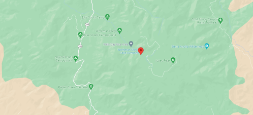 Map showing a mountainous area with roads, trails, and points of interest marked, including a red location pin.