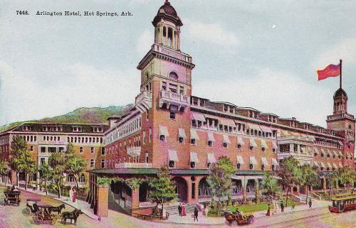 Historic postcard of the Arlington Hotel in Hot Springs, Arkansas, featuring a grand facade and surrounding trees.