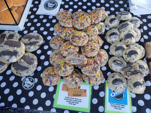 A display of cookies featuring Oreo and Reese's pieces, arranged on a polka dot tablecloth.