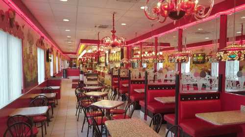 Brightly lit diner interior with red booths, tables, and decorative lighting, featuring a vibrant, colorful decor.