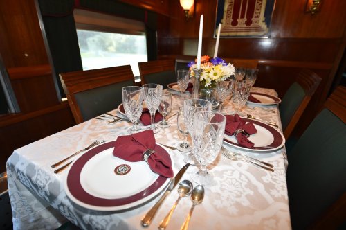 Elegant dining table set with fine china, crystal glassware, and floral centerpiece, ready for a formal meal.