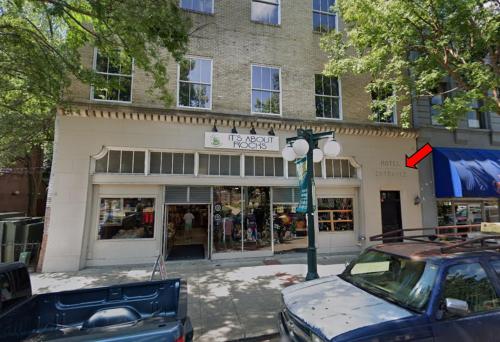 A street view of a building with a hotel entrance and a shop called "It's About Rocks" on the ground floor.