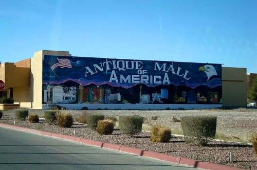 Mural of the "Antique Mall of America" featuring an eagle and American flag against a city skyline backdrop.
