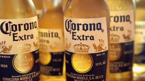 Close-up of several Corona Extra beer bottles with labels featuring a crown and text in Spanish.