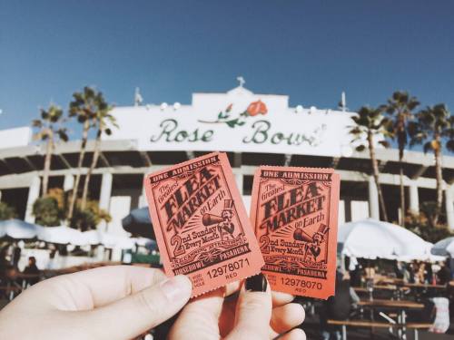 Two red admission tickets for the Rose Bowl Flea Market, held on the second Sunday of each month, against a sunny backdrop.
