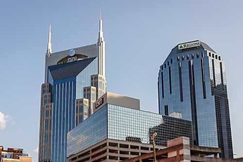 Two tall skyscrapers in an urban setting, featuring modern architecture and clear blue skies.