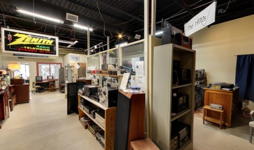Interior of a vintage electronics store featuring shelves of retro devices and a sign for Zenith.