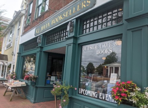 Exterior of R.J. Julia Booksellers featuring a café, books display, and a sign for upcoming events.