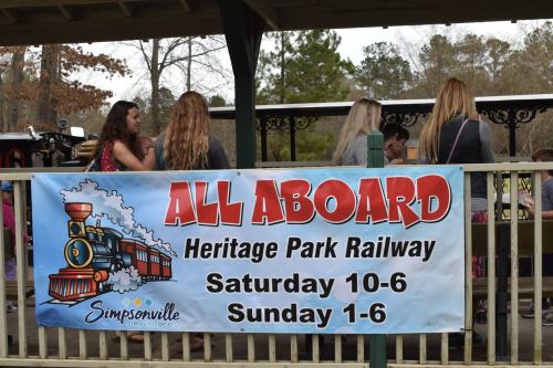 A banner promoting the Heritage Park Railway with train graphics, listing hours for Saturday and Sunday.
