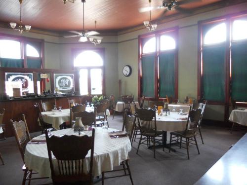A cozy restaurant interior with round tables, wooden chairs, and large windows, featuring a warm, inviting atmosphere.