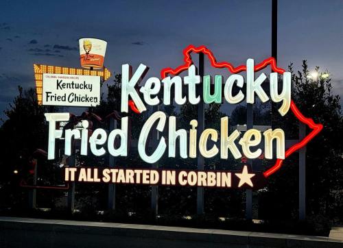 Neon sign for Kentucky Fried Chicken, featuring the phrase "It All Started in Corbin" with a Kentucky outline.