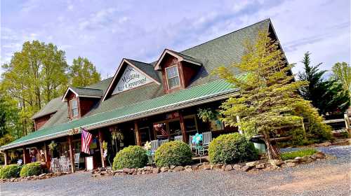 A charming lodge with a green roof, surrounded by trees and colorful chairs on the porch, set against a blue sky.