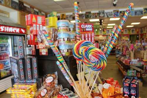 Colorful lollipops and various candies displayed in a vibrant candy shop filled with treats and snacks.