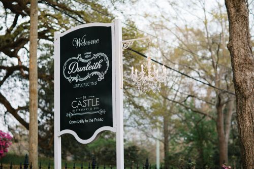 Welcome sign for Dunleith Historic Inn, featuring a chandelier and details about the Castle Restaurant & Pub.