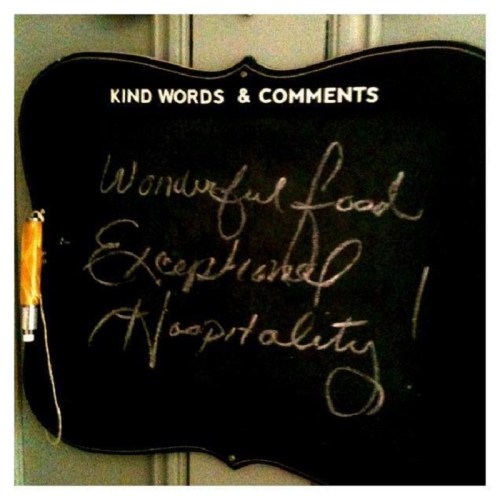 Chalkboard with handwritten text: "Wonderful food, Exceptional Hospitality!" framed by "Kind Words & Comments."