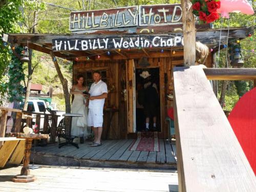 A rustic wedding chapel with a couple in wedding attire, surrounded by wooden decor and greenery.