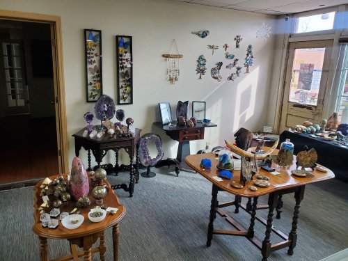 A cozy shop interior displaying various decorative items, including crystals, sculptures, and wall art.