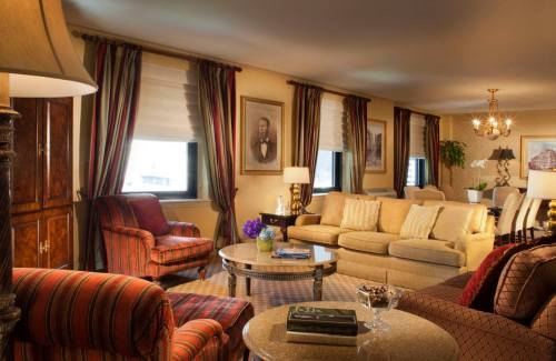 Cozy living room with elegant furniture, warm lighting, and decorative curtains, featuring a portrait on the wall.