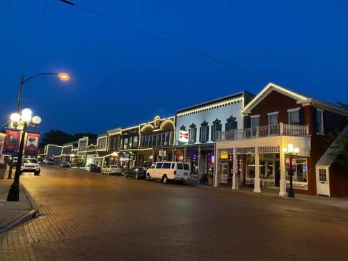 A quiet street at night, lined with historic buildings and warm lights, creating a charming atmosphere.