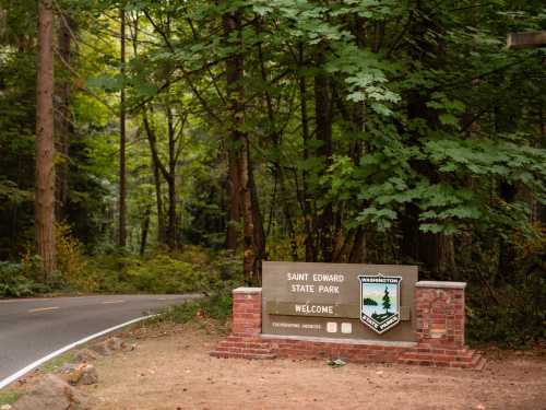 Sign for Saint Edward State Park surrounded by lush green trees, welcoming visitors to the park.