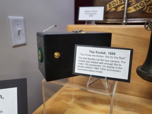 A vintage Kodak camera from 1888 displayed with an informational plaque about its history and features.