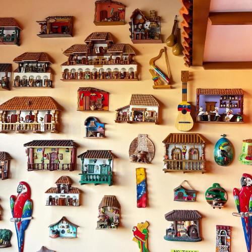 Colorful wall display featuring various decorative houses, musical instruments, and vibrant animal figures.