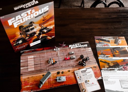 Board game "Fast & Furious: Highway Heist" with game pieces and instructions on a wooden table.