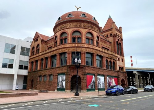 Historic building with a domed roof and intricate brickwork, featuring large windows and decorative elements.