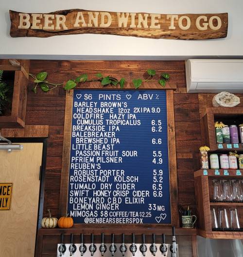 Menu board displaying beer and wine options with prices, featuring various craft beers and ciders.