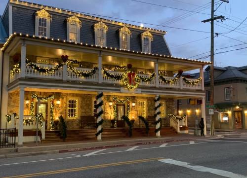 A beautifully decorated building with festive lights and garlands, set against a twilight sky.