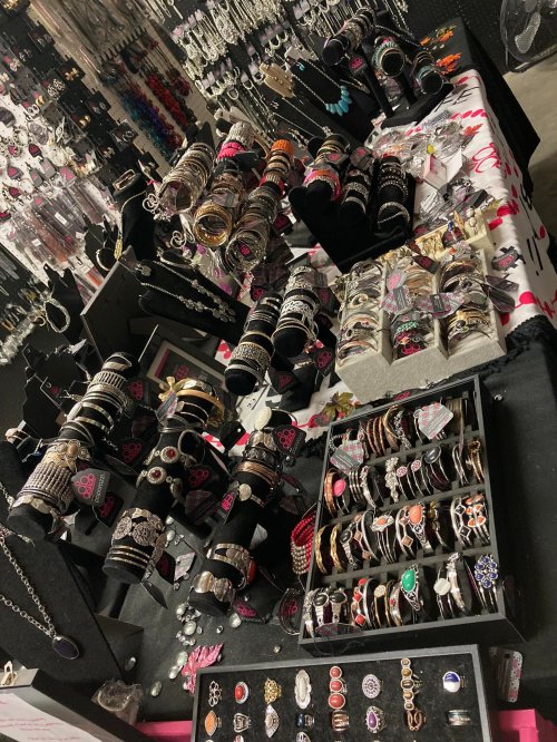 A display of various jewelry items, including bracelets, rings, and necklaces, arranged on tables and stands.