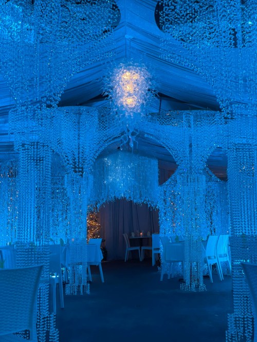 A beautifully decorated venue with blue lighting and hanging crystal-like decorations, creating a magical atmosphere.