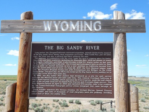 Signpost detailing the history of the Big Sandy River in Wyoming, with scenic landscape in the background.