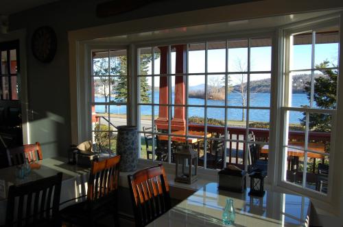 A view from inside a restaurant, showcasing a lake and outdoor seating through large windows.