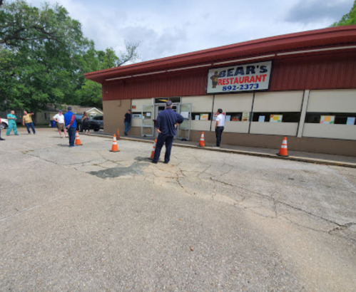 A restaurant exterior with people outside, traffic cones, and a sign reading "Bear's Restaurant."