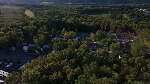 Aerial view of a wooded area with numerous RVs and campers nestled among the trees.