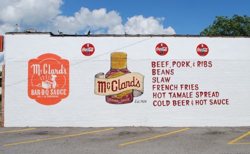 Mural featuring McClard's Bar-B-Q Sauce with menu items: beef, pork, ribs, beans, slaw, fries, and drinks. Established 1928.