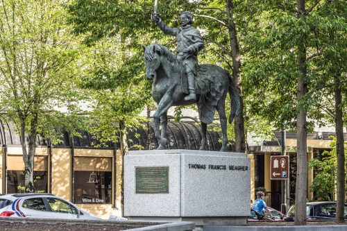 Statue of Thomas Francis Meagher on horseback, surrounded by trees and urban scenery.