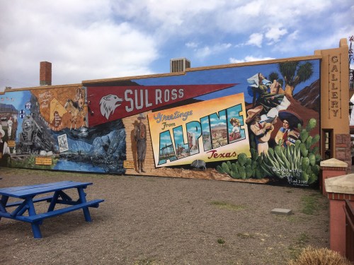 Colorful mural in Alpine, Texas, featuring local landmarks, history, and the phrase "Greetings from Alpine, Texas."