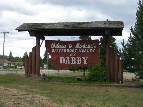Welcome sign for Darby, Montana, in the Bitterroot Valley, featuring wooden structure and star design.