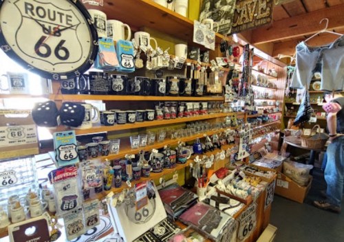 A vibrant display of Route 66 souvenirs, including mugs, keychains, and various memorabilia on wooden shelves.